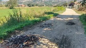 Buche in strada tappate con rifiuti pericolosi